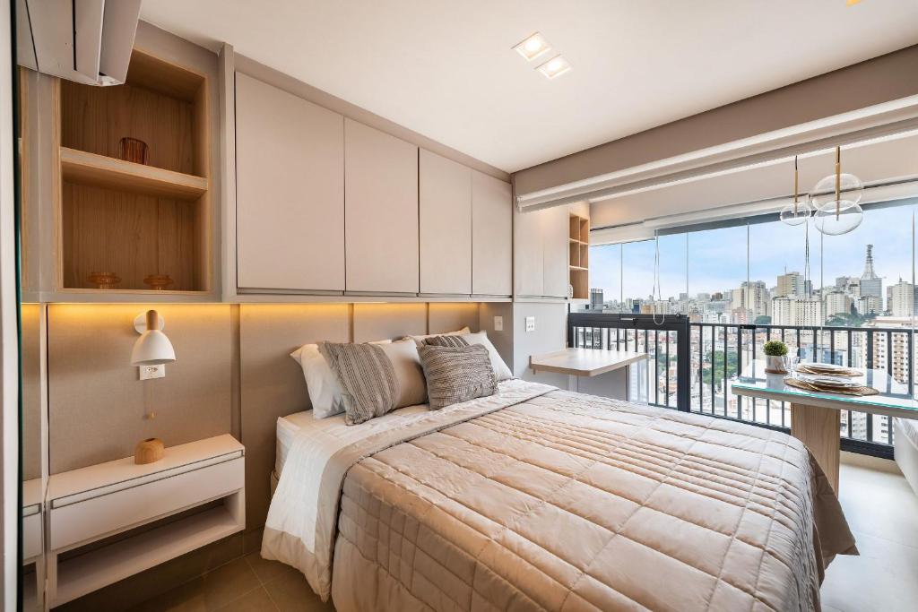 1 dormitorio con 1 cama grande y balcón en FO24 - Studio de Luxo ao Lado do Shopping Frei Caneca, en São Paulo