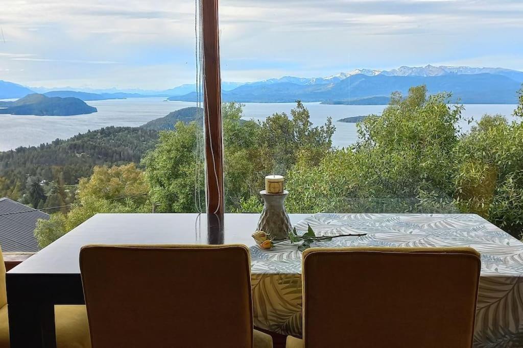 - une table à manger avec vue sur l'eau dans l'établissement Cabaña de montaña en Cerro Otto con increible Vista al Lago, à San Carlos de Bariloche
