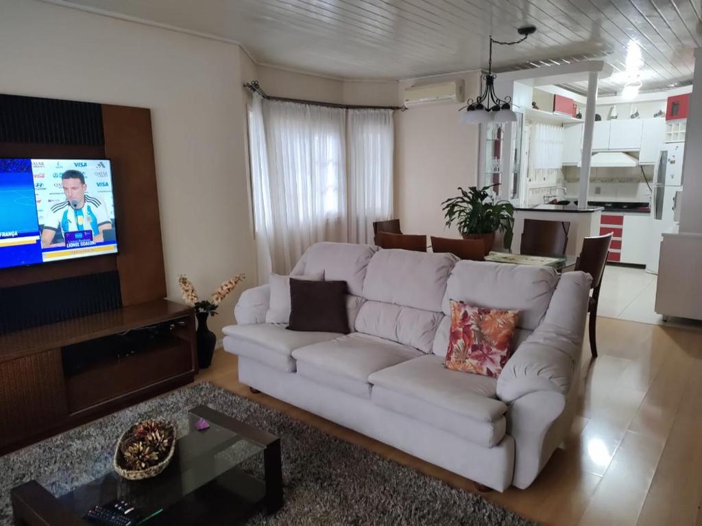 sala de estar con sofá blanco y TV en Casa Matriz Palace, en Canela