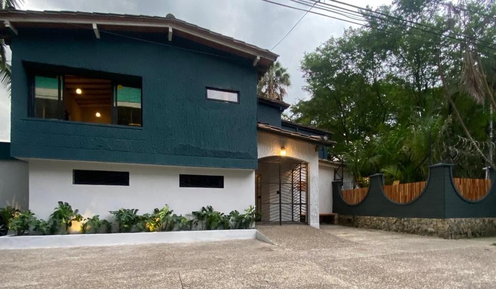 una casa azul y blanca con garaje en Hostal Casa Mosaiko Patio Bonito Poblado, en Medellín
