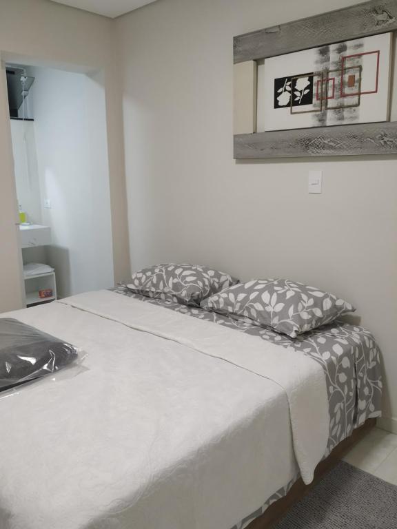 uma cama com duas almofadas num quarto em A Pousadinha em Águas de São Pedro