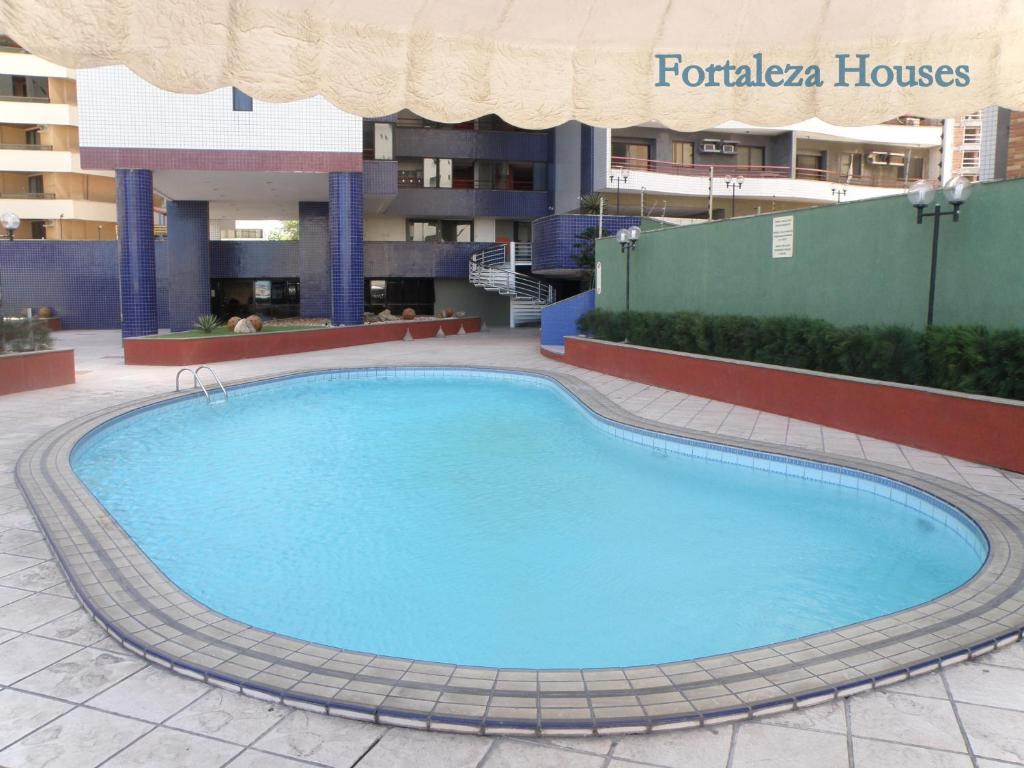 a large swimming pool in front of a hotel at Porto de Iracema - Fortaleza houses in Fortaleza