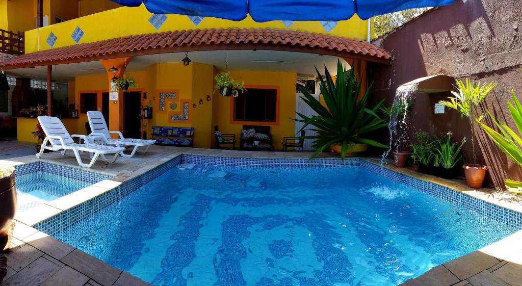 a swimming pool in front of a house at Beira Mar Bertioga in Bertioga