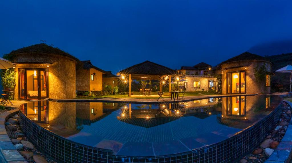 uma imagem de uma piscina de resort à noite em Sapa Farmstay em Sapa