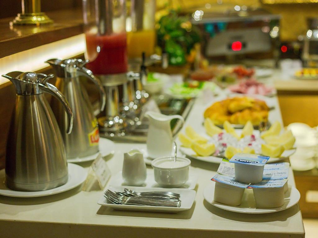Emerald Boutique Hotel في هانوي: طاولة مطبخ مع طاولة عليها طعام