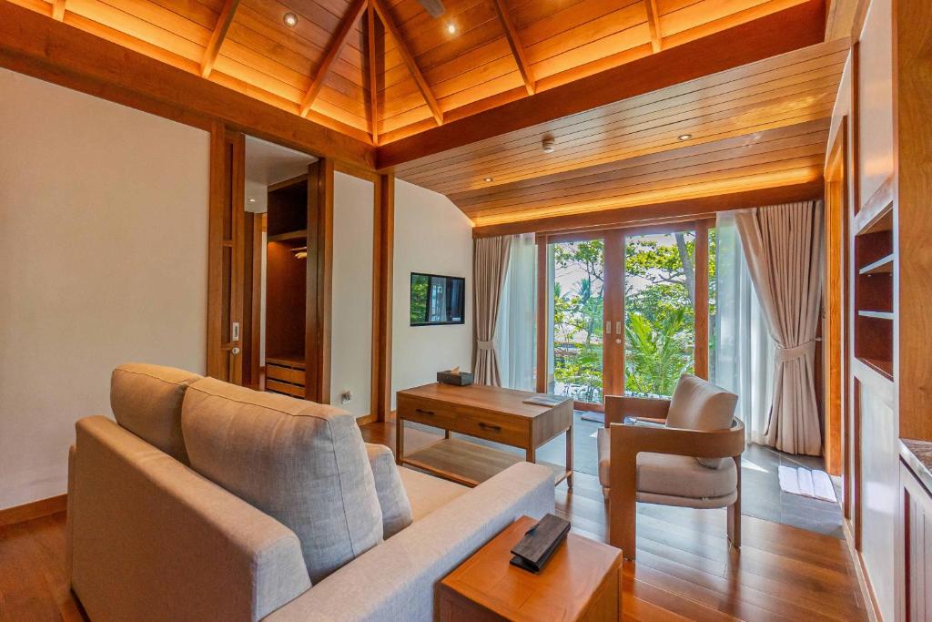 a living room with a couch and a table at The Surin Phuket in Surin Beach