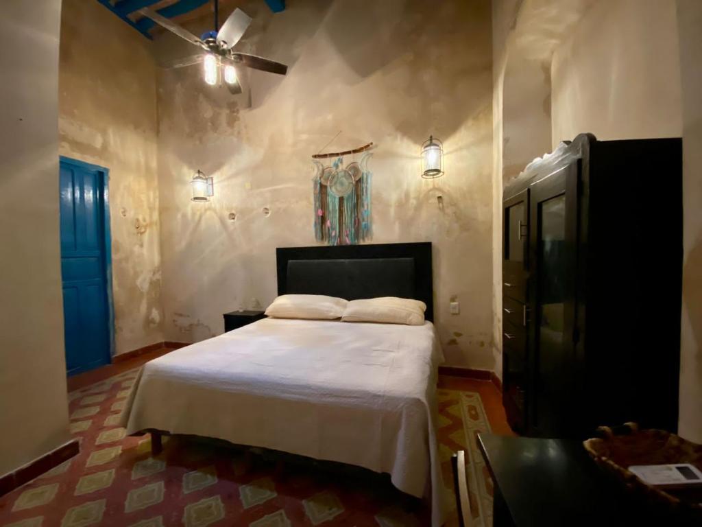 hotel xucum في كامبيش: غرفة نوم بسرير ومروحة سقف