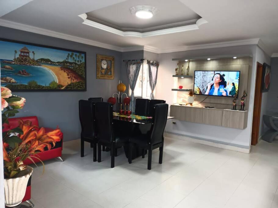 a living room with a table and chairs and a tv at Apartamento amplio, confortable aire acondicionado in Ríohacha