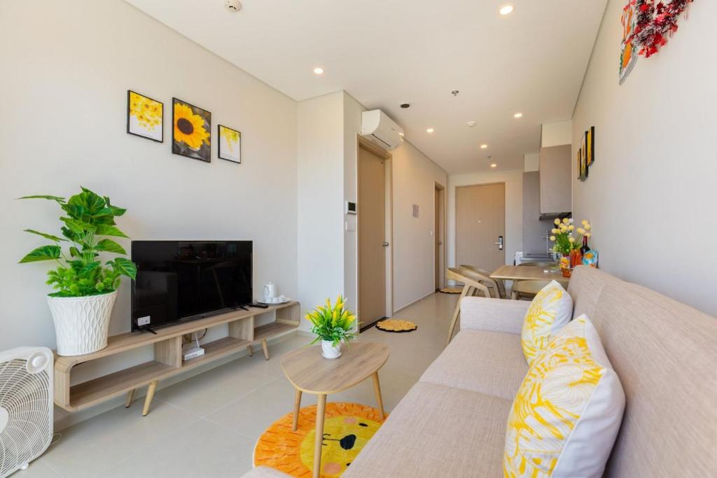 a living room with a couch and a tv at Căn hộ Studio The Sóng Vũng Tàu in Vung Tau