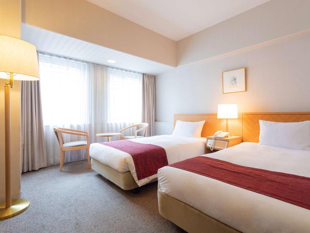 Postel nebo postele na pokoji v ubytování The Saihokukan Hotel
