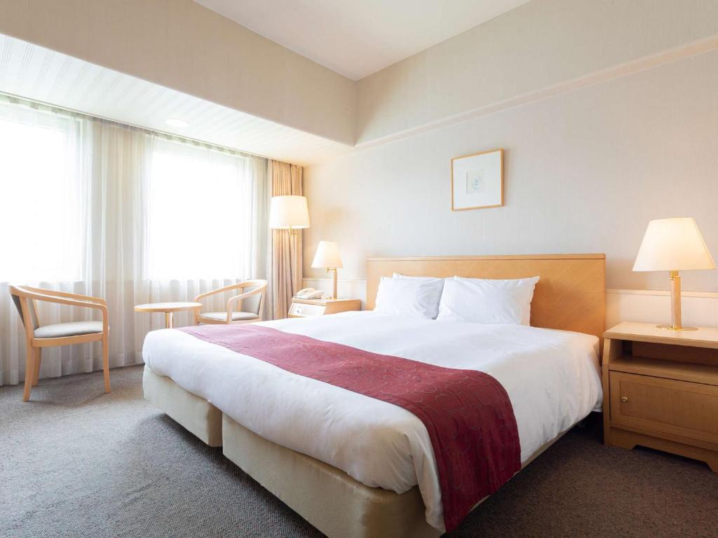 Postel nebo postele na pokoji v ubytování The Saihokukan Hotel