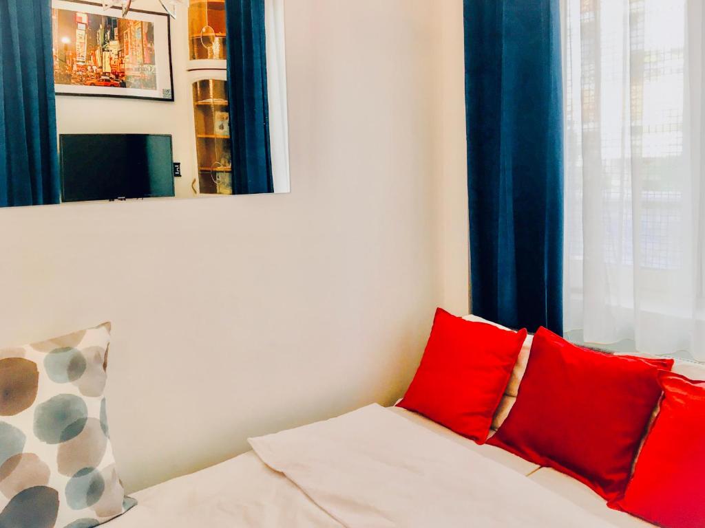 un sofá blanco con almohadas rojas en una habitación en Jasmine Studio, en Radom