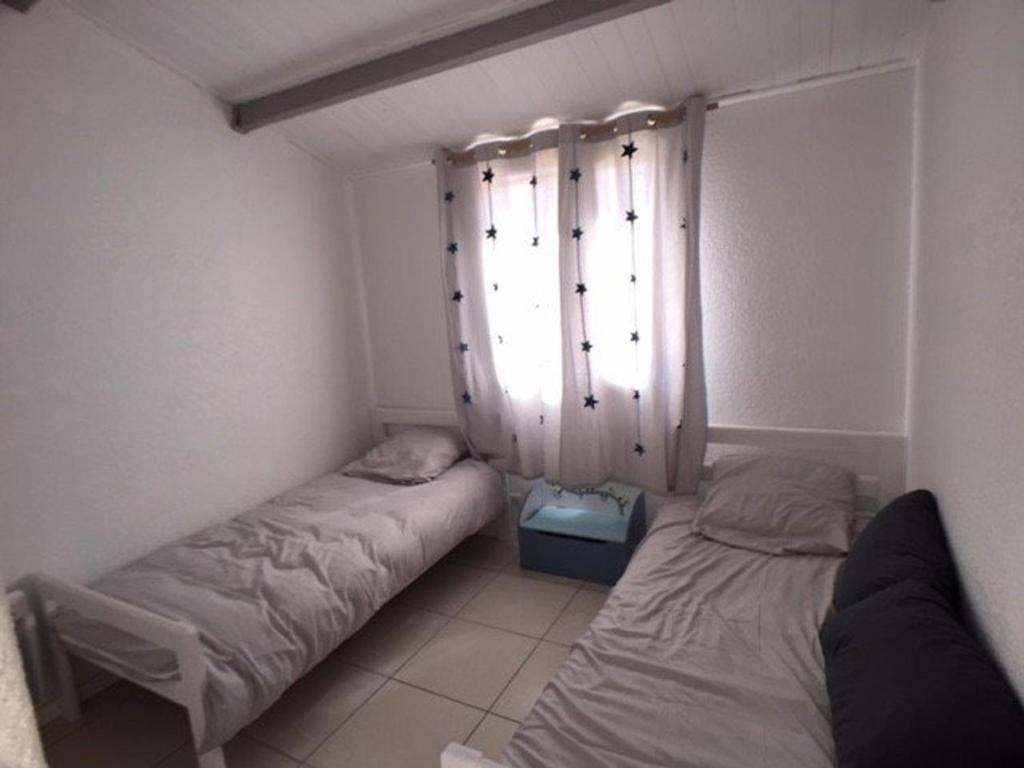 Habitación pequeña con 2 camas y ventana en Appartement Port Leucate, 3 pièces, 6 personnes - FR-1-81-428, en Port Leucate