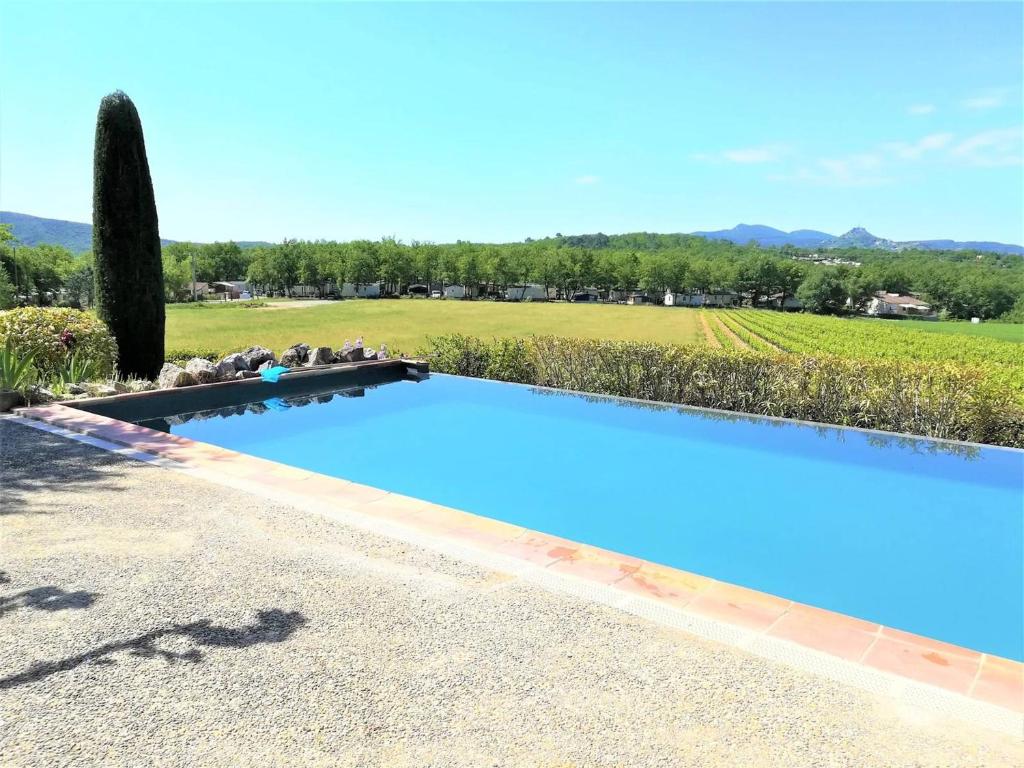 una gran piscina azul junto a un campo verde en Maison Lagorce, 5 pièces, 8 personnes - FR-1-382-110 en Lagorce