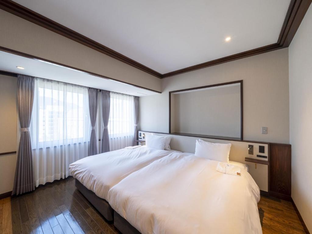 Postel nebo postele na pokoji v ubytování The Saihokukan Hotel