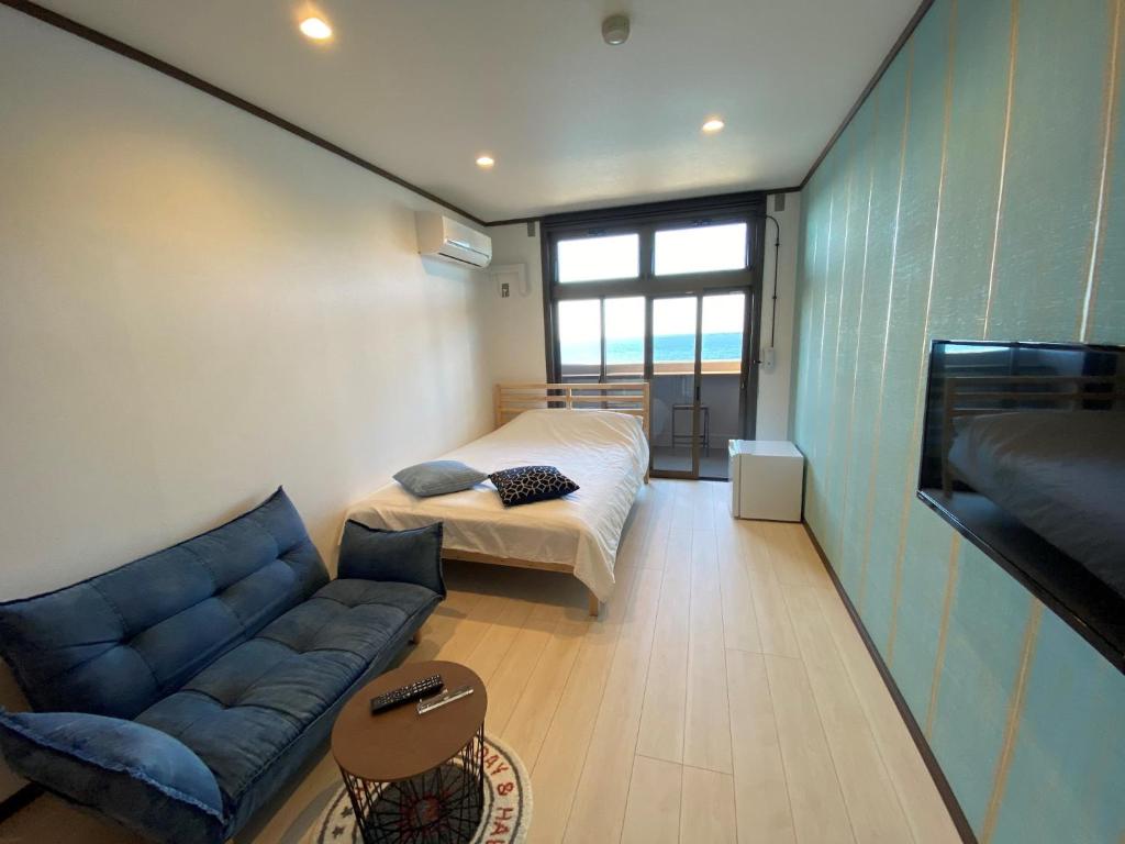 - un salon avec un canapé et un lit dans l'établissement seaside villa HILIFE - Vacation STAY 99007, à Kogushi