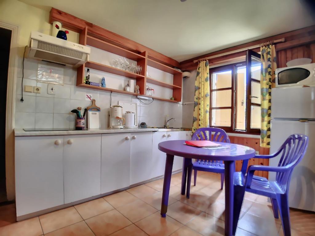 uma cozinha com uma mesa roxa e duas cadeiras em Appartement Saintes-Maries-de-la-Mer, 2 pièces, 2 personnes - FR-1-475-33 em Saintes-Maries-de-la-Mer