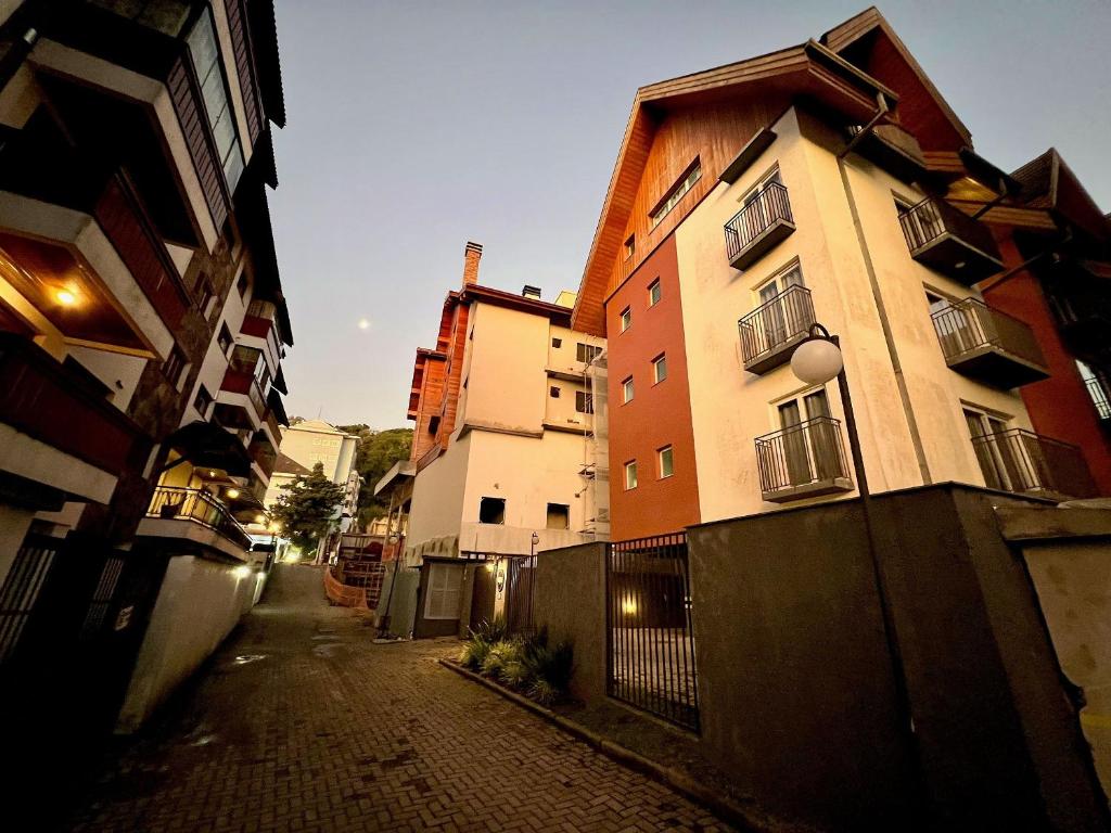 an alley way with a building and a fence at Apartamentos Onze1 no CENTRO by Achei Gramado in Gramado