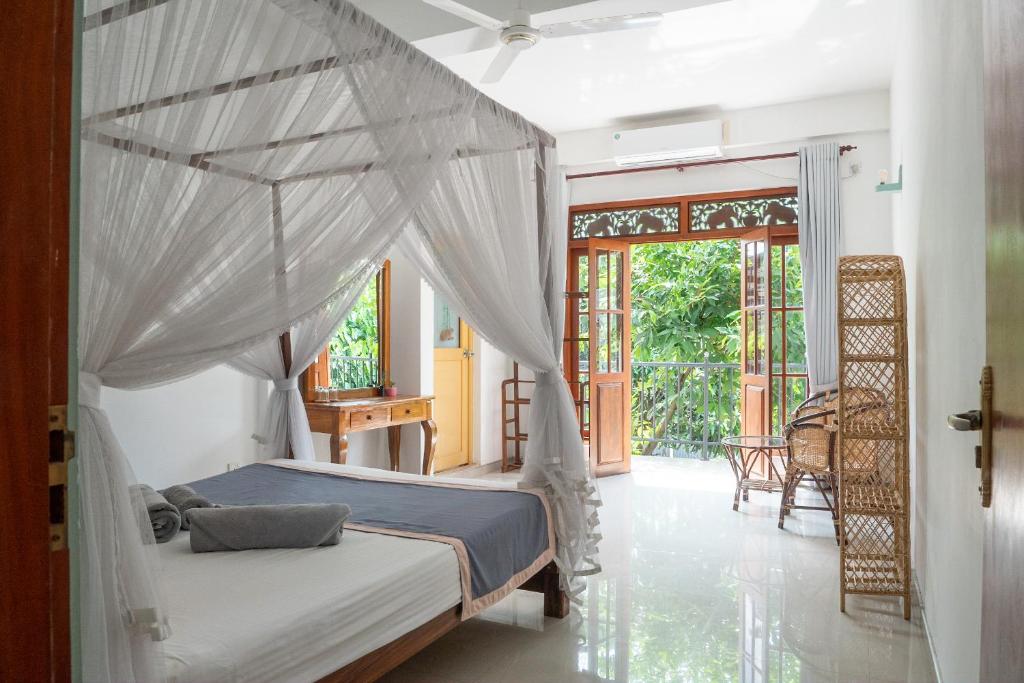 a bedroom with a bed with a canopy at Rise - Bed & Breakfast in Weligama