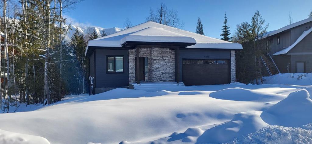 a house with a garage covered in snow at Fernie Escape - Mountain Home on the Ski Hill in Fernie