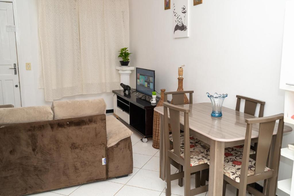 sala de estar con mesa y sofá en Casa de Praia, en Porto Belo