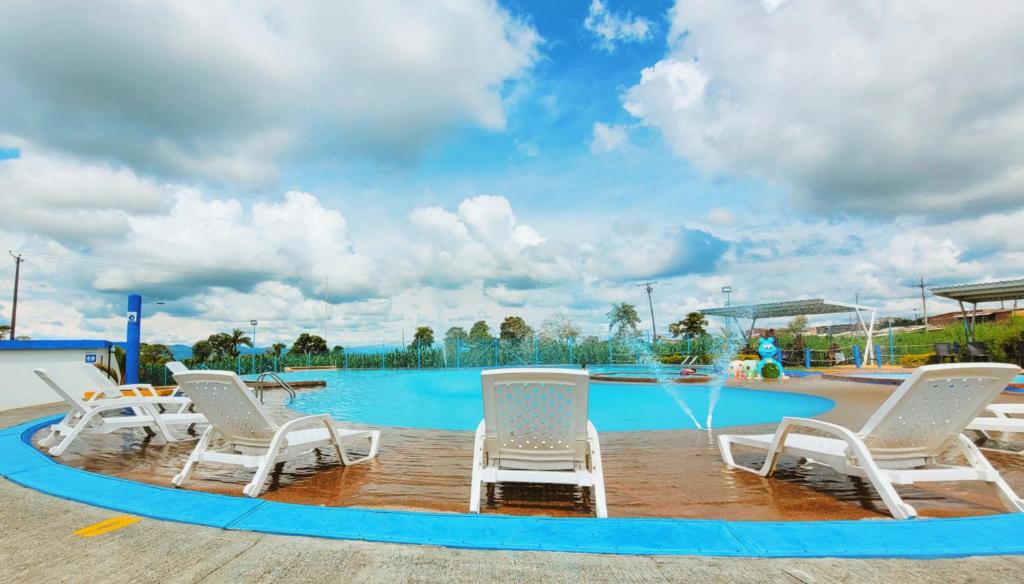 un gruppo di sedie intorno alla piscina di Apto con Piscina a 5min del Parque Nacional Del Café a Montenegro