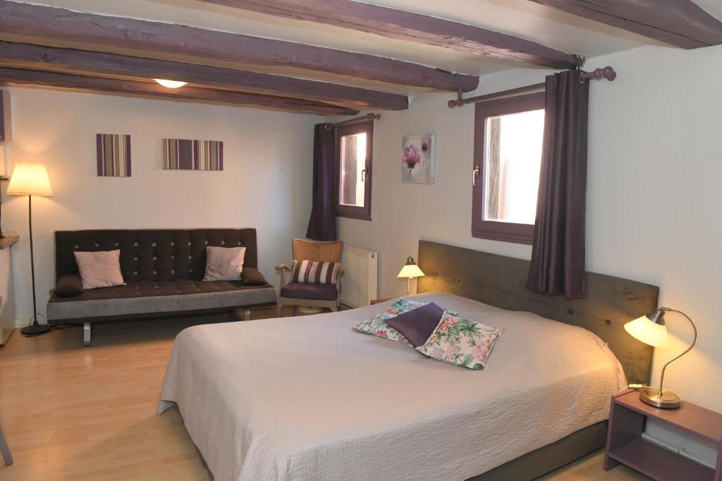 a bedroom with a bed and a couch at CHEZ CECILE Bed and Breakfast chez le VIGNERON in Colmar