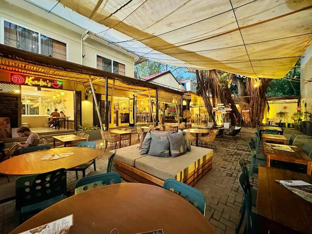 ein Restaurant mit Tischen und ein Bett in einem Zimmer in der Unterkunft BAMBAM Hostel in Coron