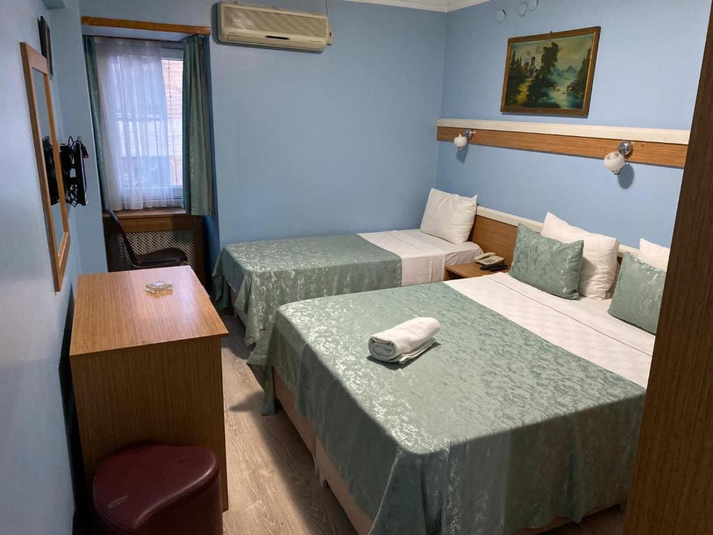 Zimmer mit 2 Betten, einem Tisch und einem Stuhl in der Unterkunft Hotel Oz Villa in Istanbul
