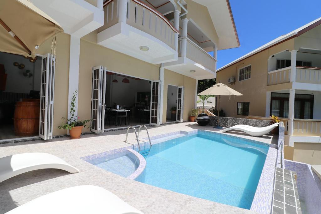 a swimming pool in the backyard of a house at Mountain View Hotel in La Digue