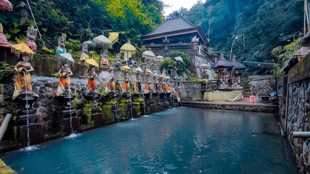 a large pool of water in front of a building at Penglukatan Dasa Mala Lan Tirta Widiadari in Susut