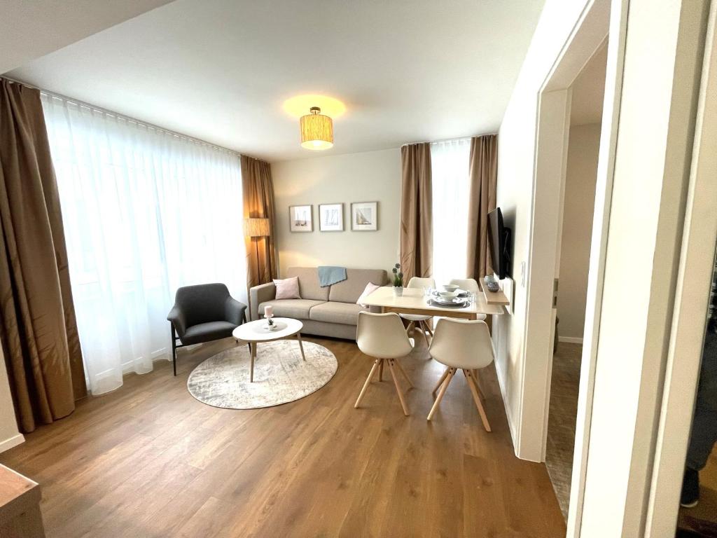 a living room with a couch and a table and chairs at Baltic Lagoon Resort - Appartement 12 in Fuhlendorf