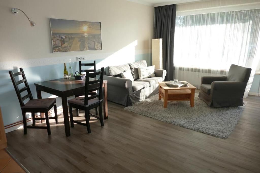 ein Wohnzimmer mit einem Sofa, einem Tisch und Stühlen in der Unterkunft Baltic Nr. 5 in Scharbeutz