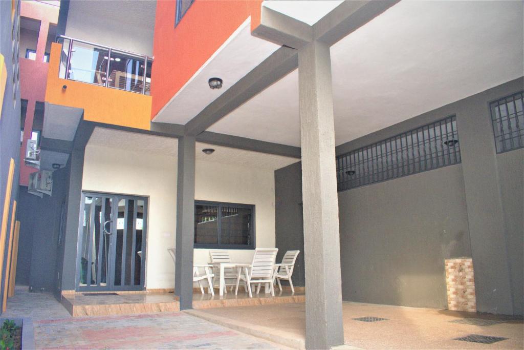 a house with a balcony and a table and chairs at RÉSIDENCE BELLEVUE SITO AIPORT- Lomé in Lomé