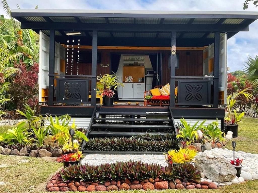 una piccola casa con portico e giardino di Are Mii a stylish one room container home a Rarotonga
