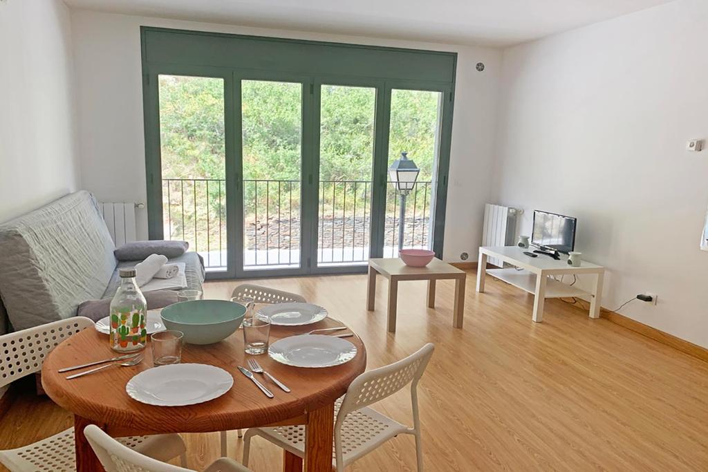 a living room with a wooden table and chairs at Apartamentos Canillo 3000 in Canillo