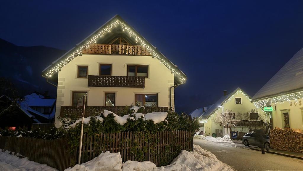 Biały dom z lampkami świątecznymi w obiekcie Apartma Uršič w mieście Kranjska Gora