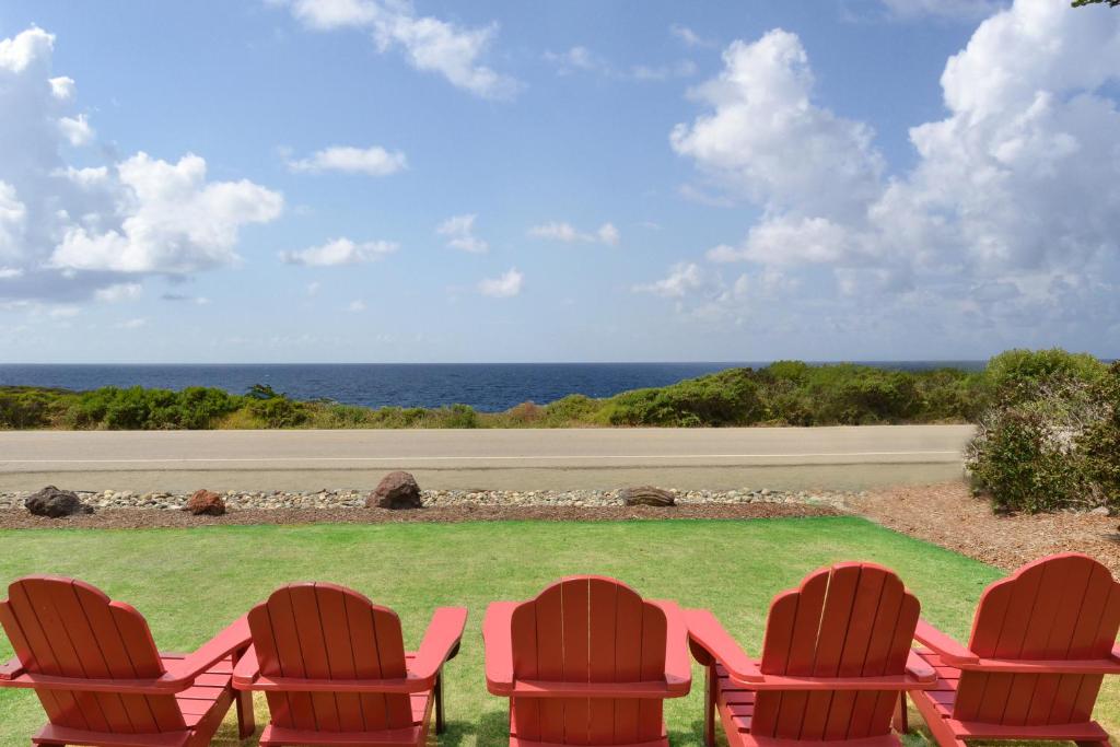 a group of chairs sitting on a lawn with the ocean at Castle Inn in Cambria
