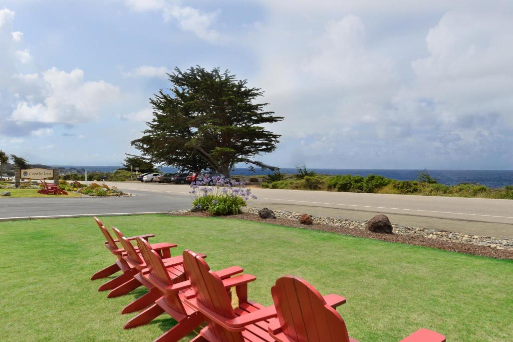 a group of chairs sitting on the grass near a road at Castle Inn in Cambria