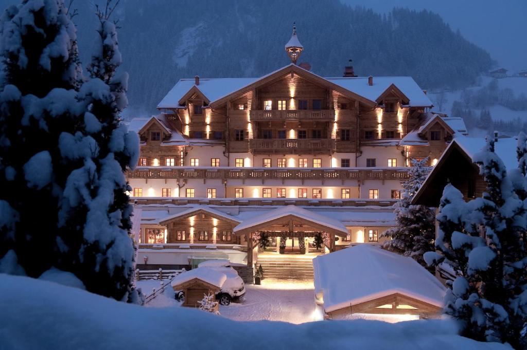 un grand hôtel dans la neige la nuit dans l'établissement Grossarler Hof Superior, à Grossarl