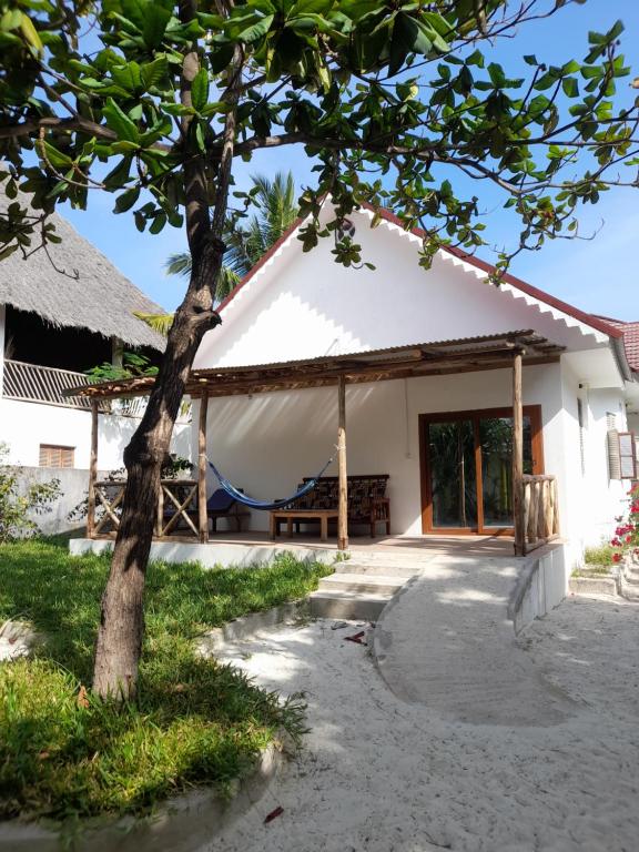 a house with a tree in front of it at Culture's apartment in Paje