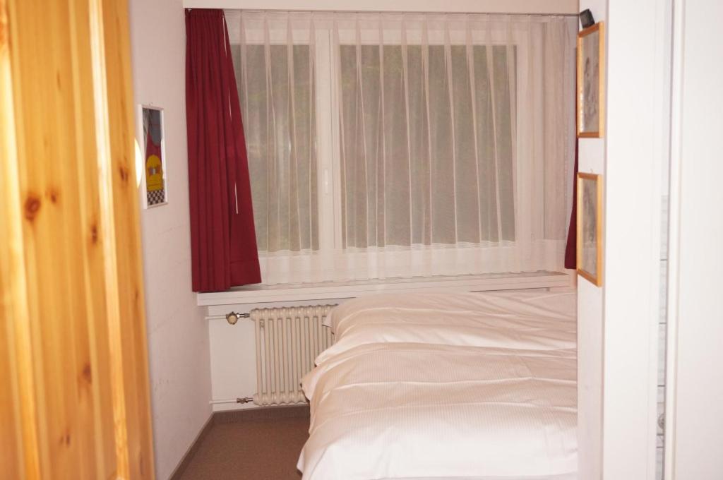ein Bett in einem Zimmer mit einem Fenster und einem Bett sidx sidx in der Unterkunft Paradies 104 in Arosa