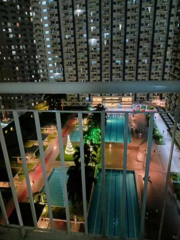 a view of a swimming pool at night at 1 BR with poolside view balcony in Manila