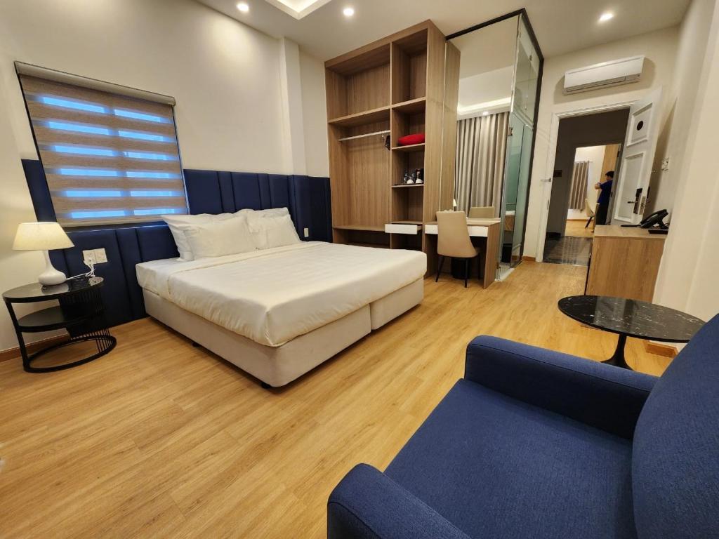 a bedroom with a bed and a living room at Ruby Hotel in Ho Chi Minh City