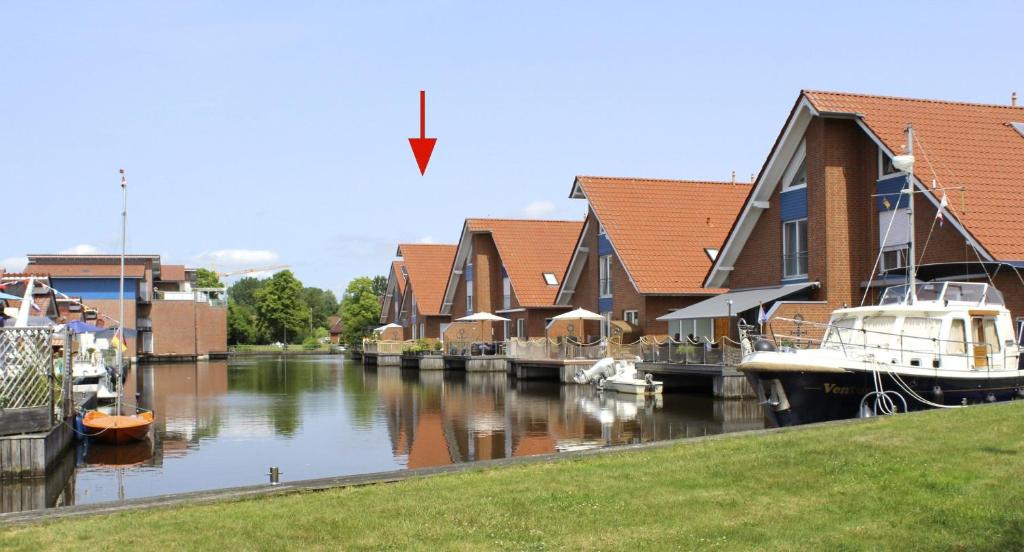 un grupo de casas y barcos en un río en Ferienwohnung Seegang 25493, en Weener