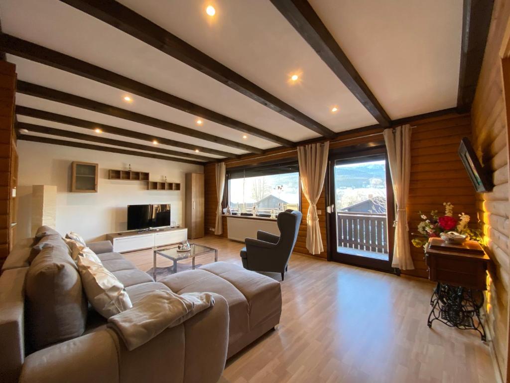 a large living room with a large couch and chairs at Feriendorf am Hohen Bogen Arrach Haus 69 OG in Arrach