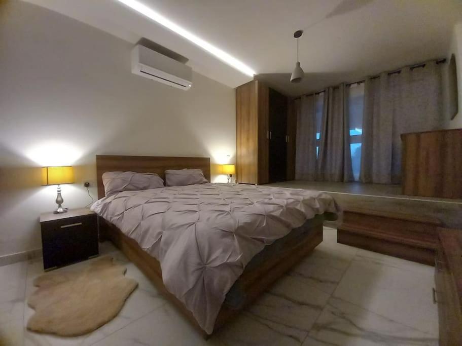 a bedroom with a large bed and a window at Brand new 1 bedroom studio flat in Gudja