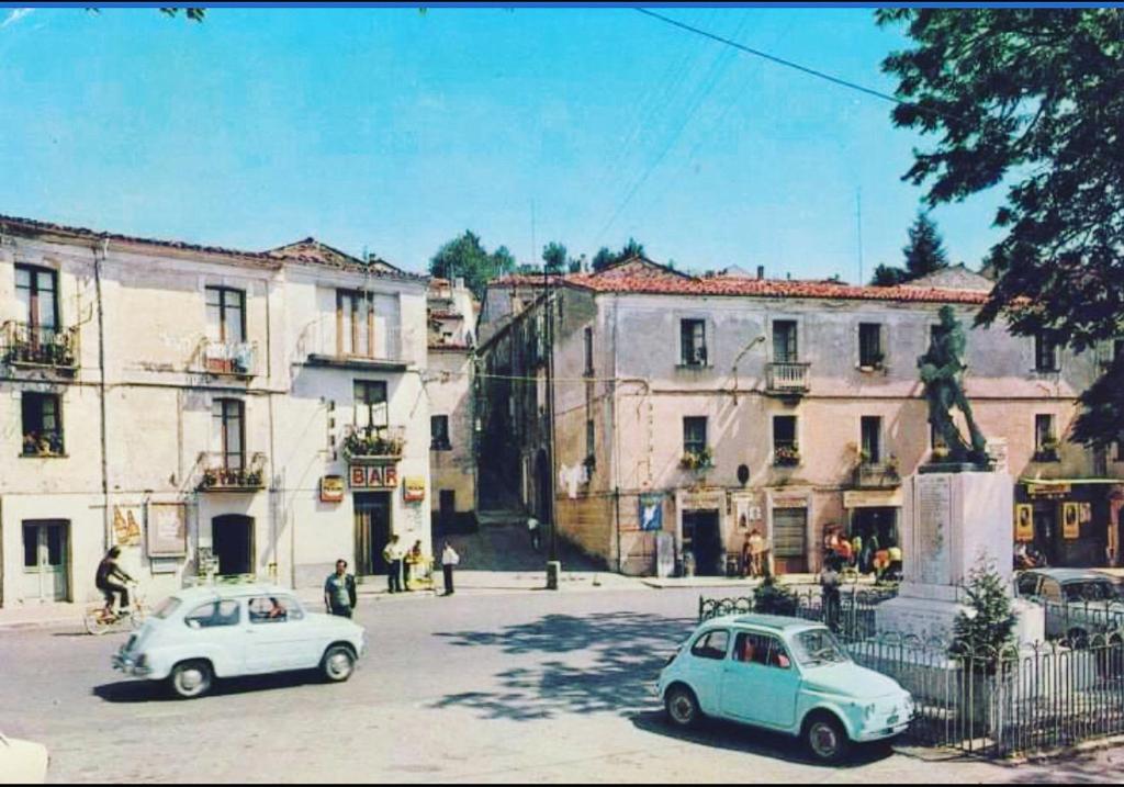 dos coches viejos estacionados en una calle frente a los edificios en L'arco di corso Garibaldi 202 en Soveria Mannelli