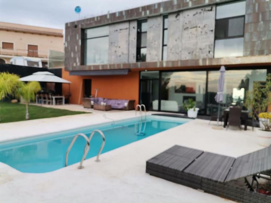 una piscina frente a una casa en RENACER, Valencia a 30 minutos, Piscina y casa privadas para el huésped, Private pool and house for the guest, en Casinos
