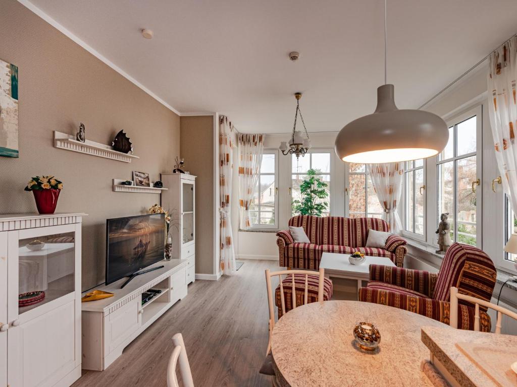 a living room with a table and chairs and a tv at Villa Christiane Wohnung 8 in Heringsdorf